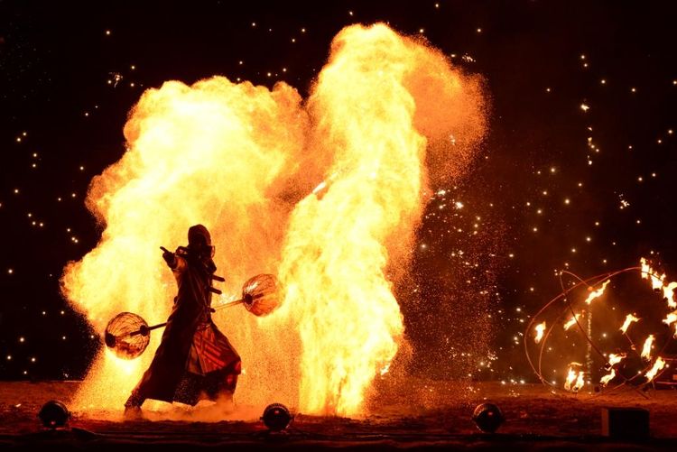 Un comédien devant un immense feu lors du spectacle nocturne d'Elusa